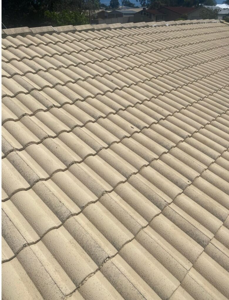 Old and dirty beige tile roof prior to professional roof cleaning and painting